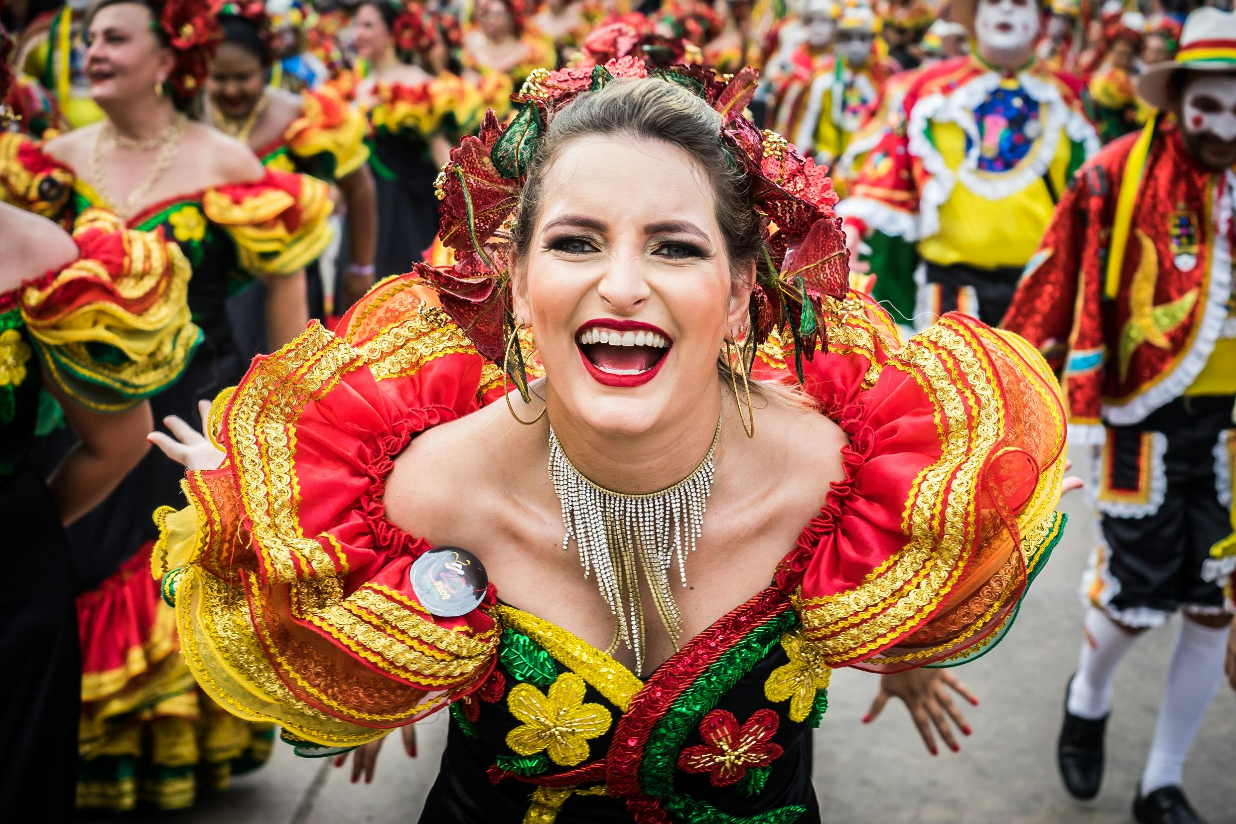 Smiling woman in colorful traditional attire at Barranquilla Carnival in Colombia.