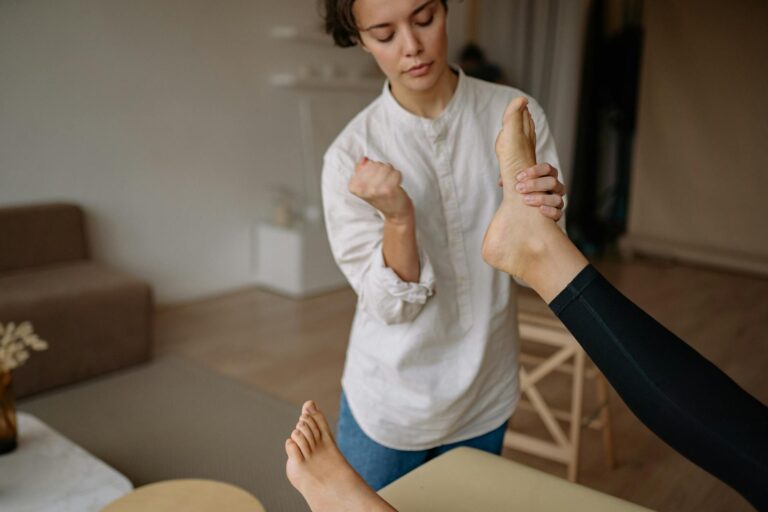 A massage therapist gives a relaxing foot therapy session in a calm indoor setting.