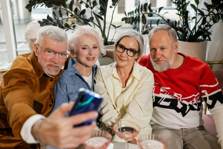 A group of senior friends capture a cheerful selfie indoors, enjoying quality time together.